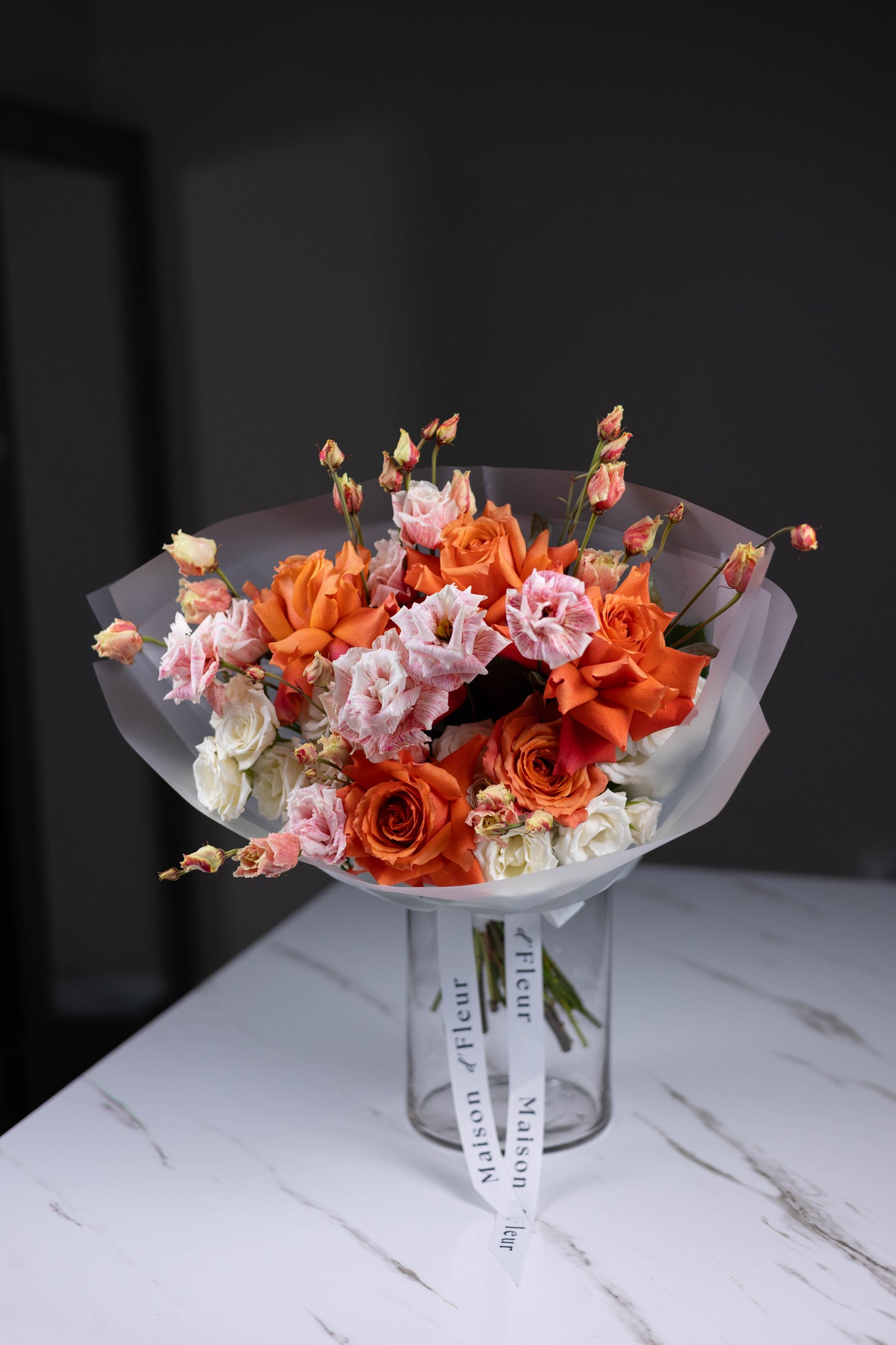 Modern flower arrangement with orange roses and lisianthus