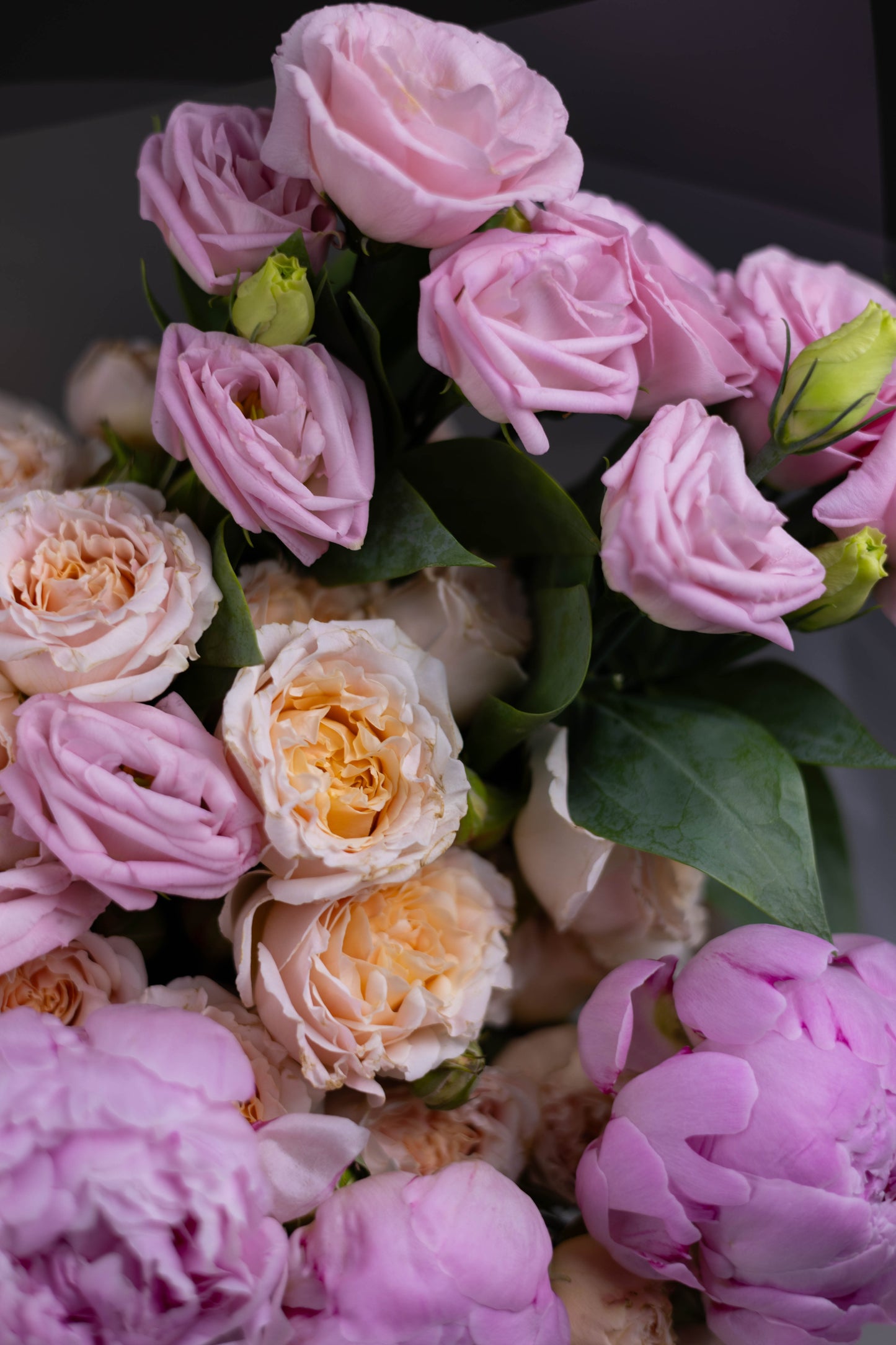 Side focus on lavender lisianthus blooms and fresh green buds, part of a soft-toned spring bouquet.