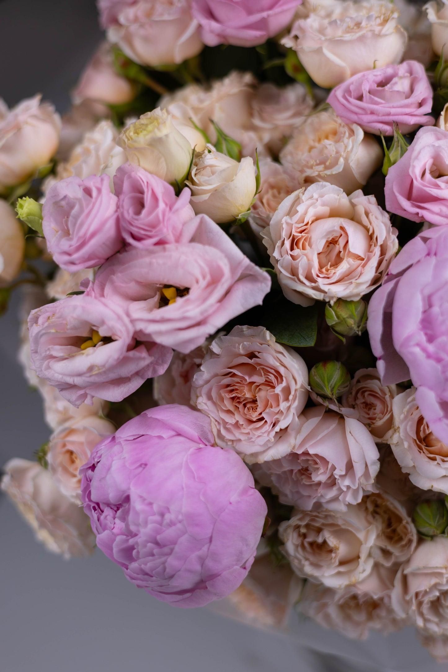 Macro shot of lisianthus, peonies, and spray roses in blush and cream tones, capturing the bouquet’s texture and freshness.