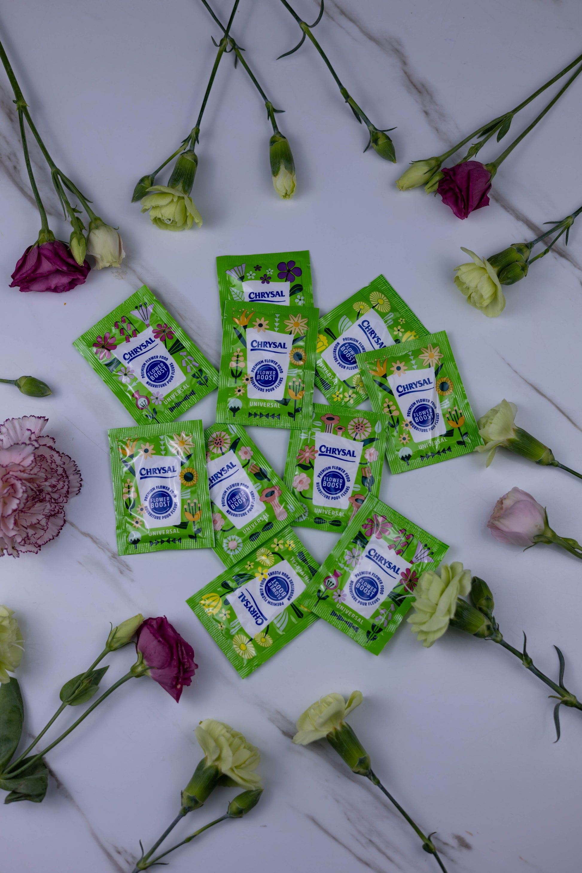 Green packets with a brand logo surrounded by flowers on a white background