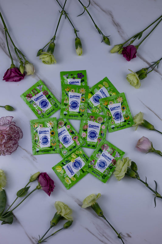 Green packets with a brand logo surrounded by flowers on a white background