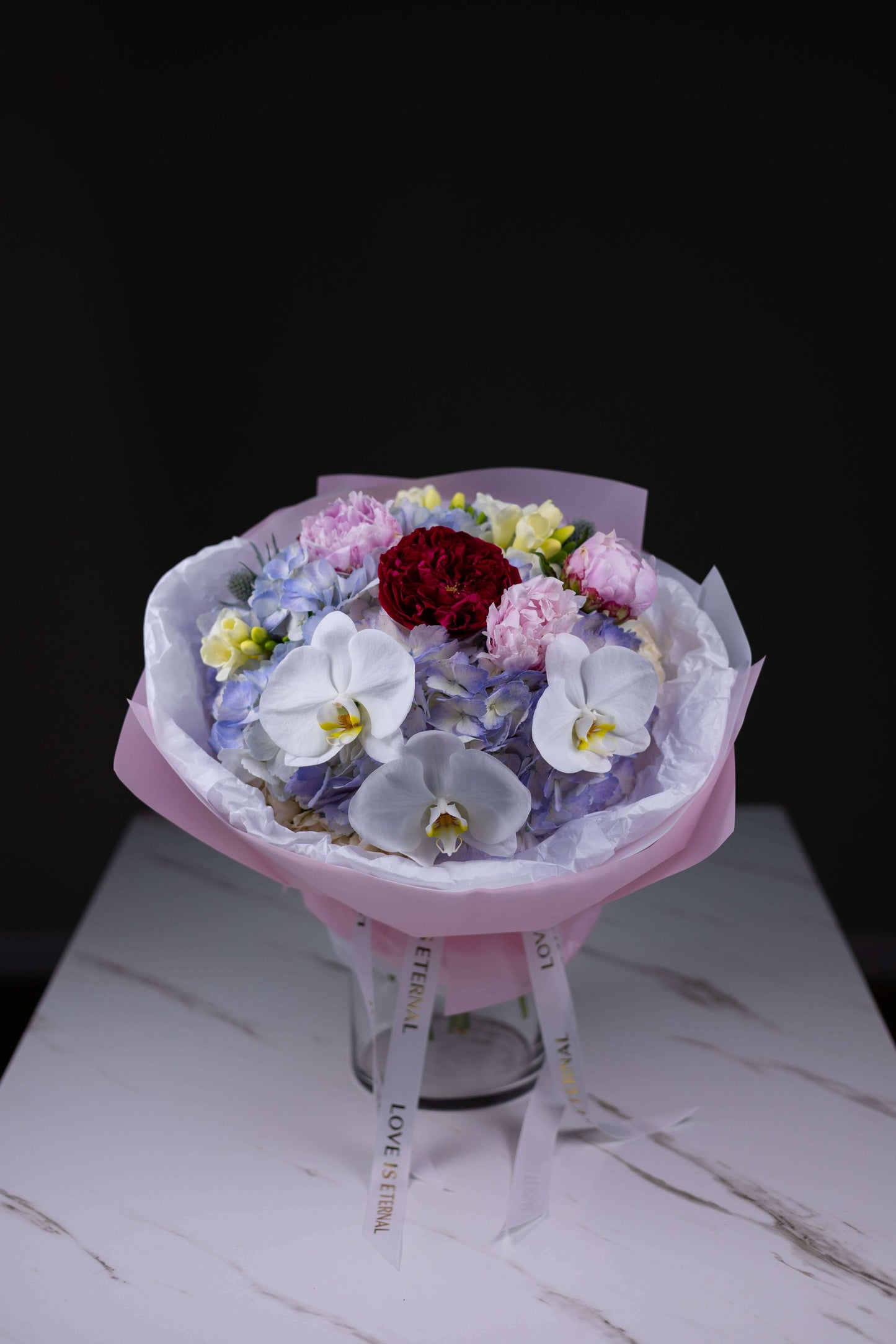 Luxury flower bouquet with red garden roses, white orchids, and blue hydrangeas by Maison d’Fleur Charlotte