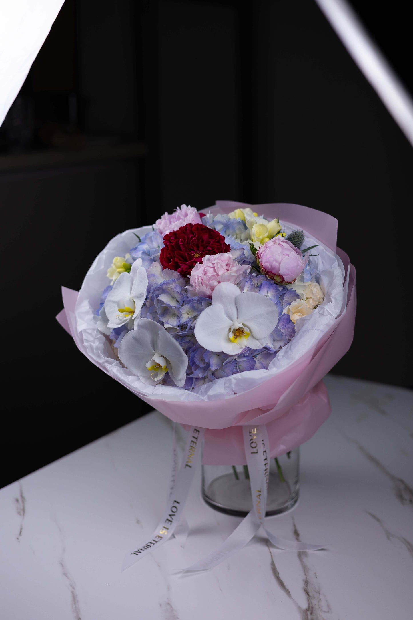 Bold and romantic floral design with red roses and white phalaenopsis orchids by Maison d’Fleur florist