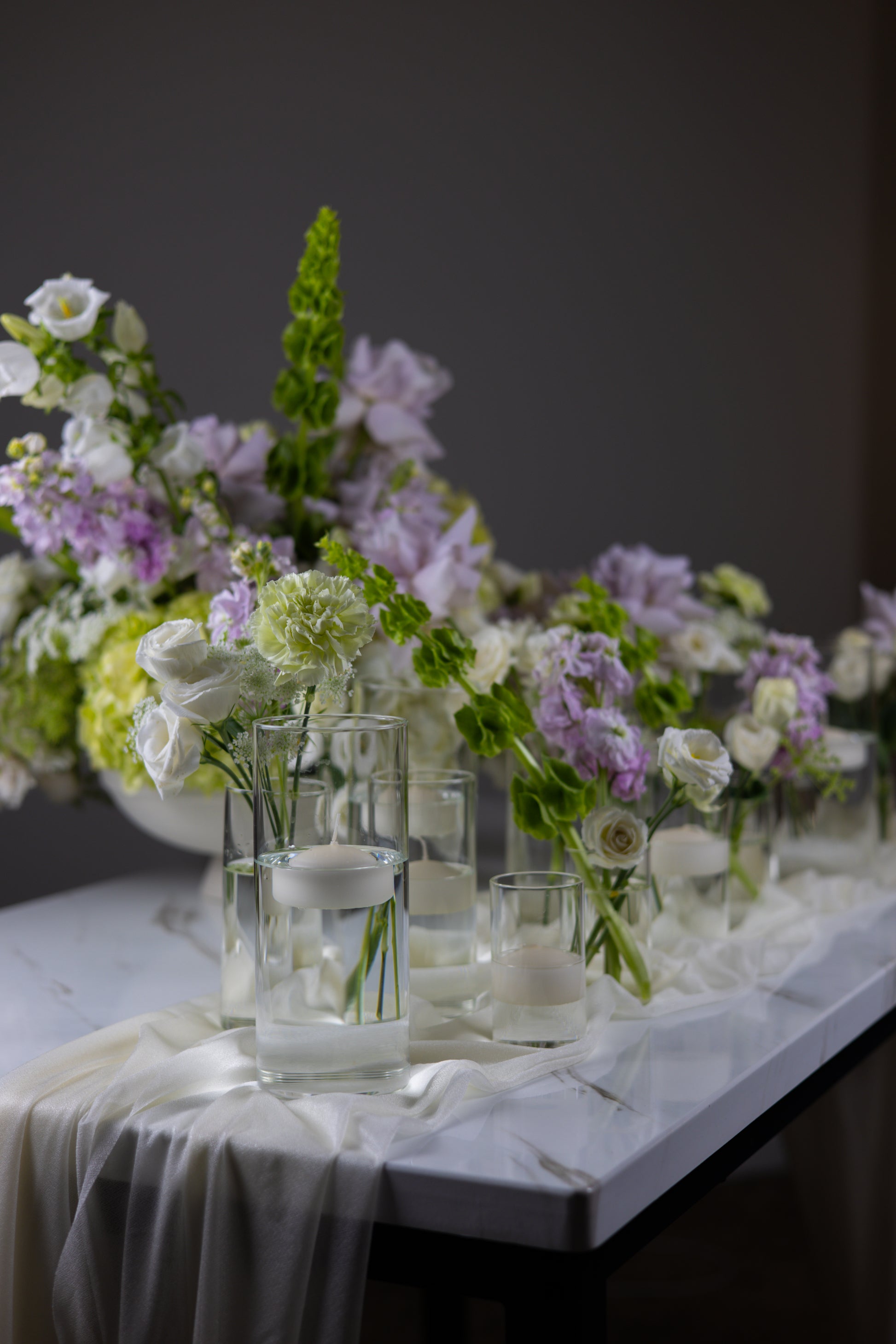 Decorative table setting with flowers and candles on a gray background