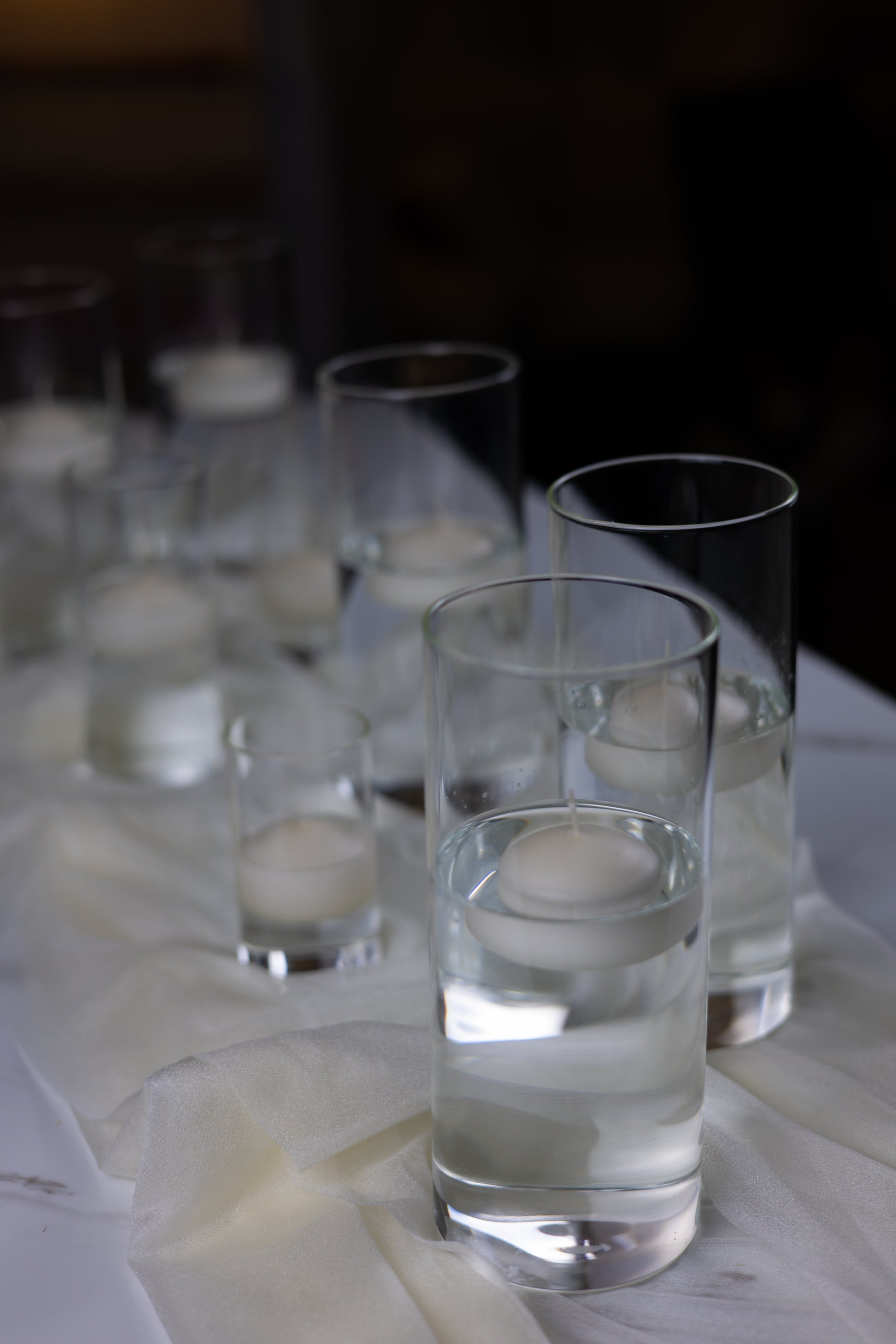 Clear glasses filled with water on a white surface