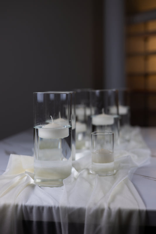 Decorative candles in glass holders on a table with a blurred background