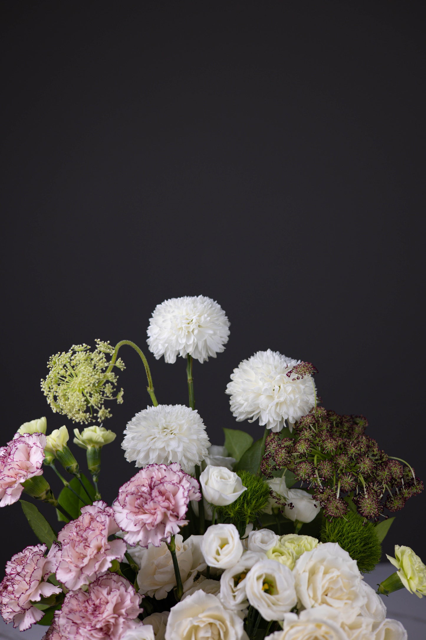 Top portion of floral arrangement showcasing white dahlias, Queen Anne’s lace, and rich textures