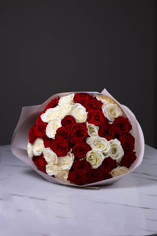 Bouquet of red, white, and cream roses on a dark background
