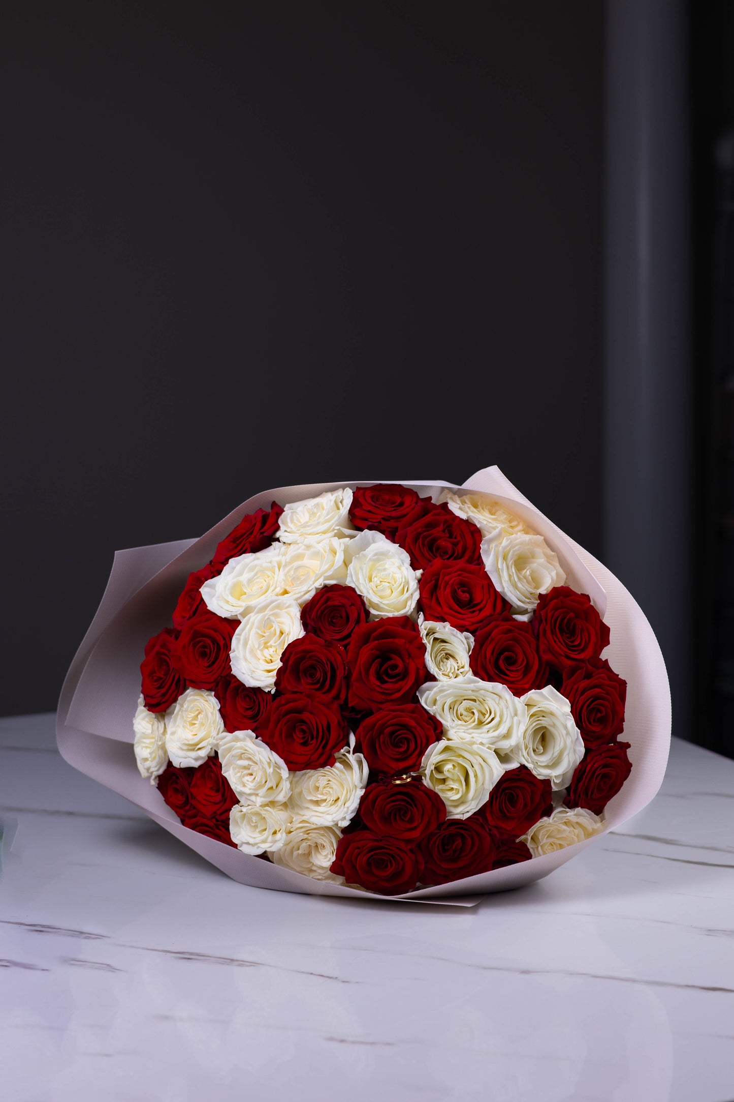 Bouquet of red and white roses on a dark background
