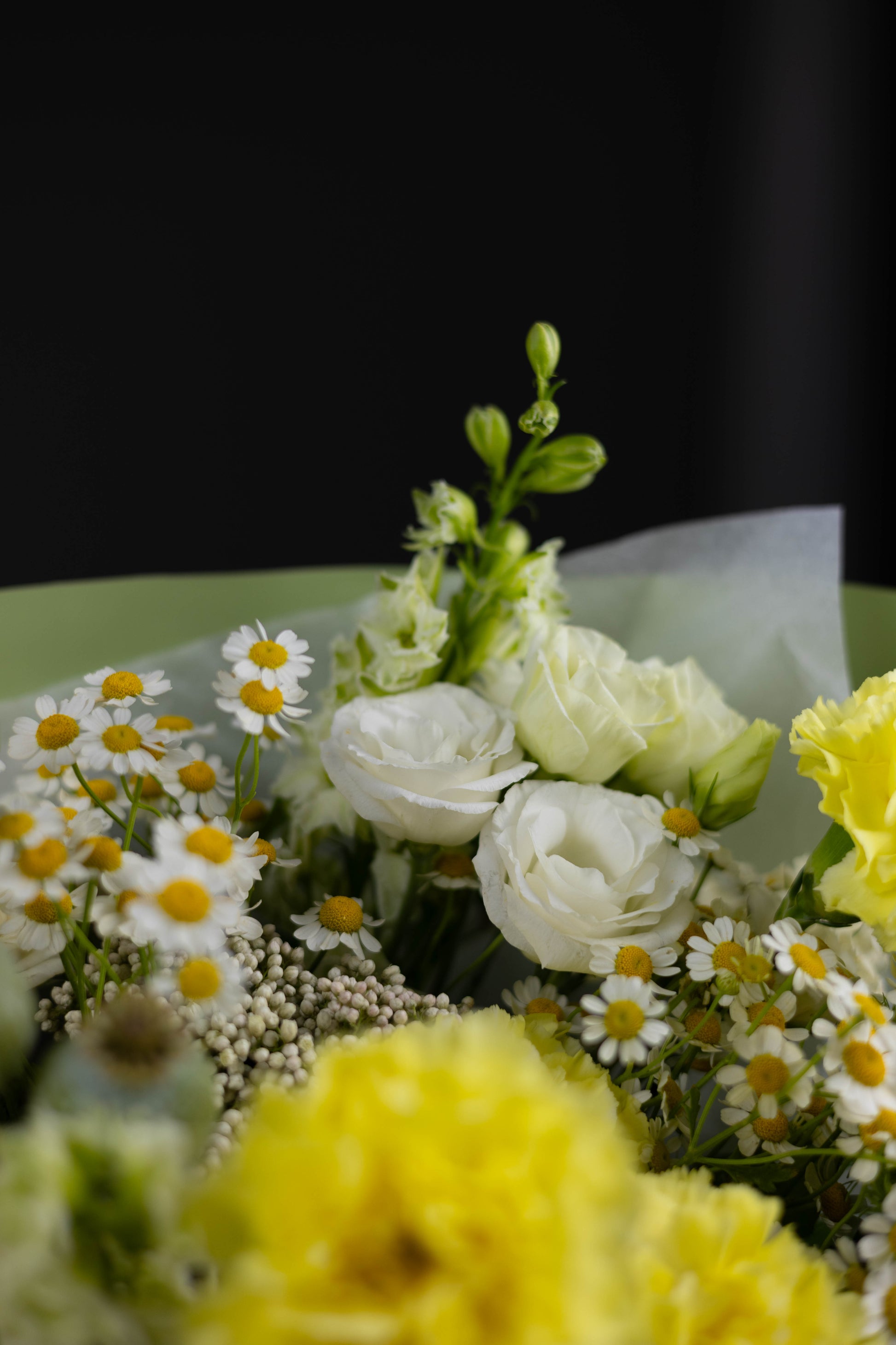 Close-up of a bouquet highlighting fresh chamomile flowers, white lisianthus, and green buds with visible petal textures and natural gradients, symbolizing freshness and countryside charm.
