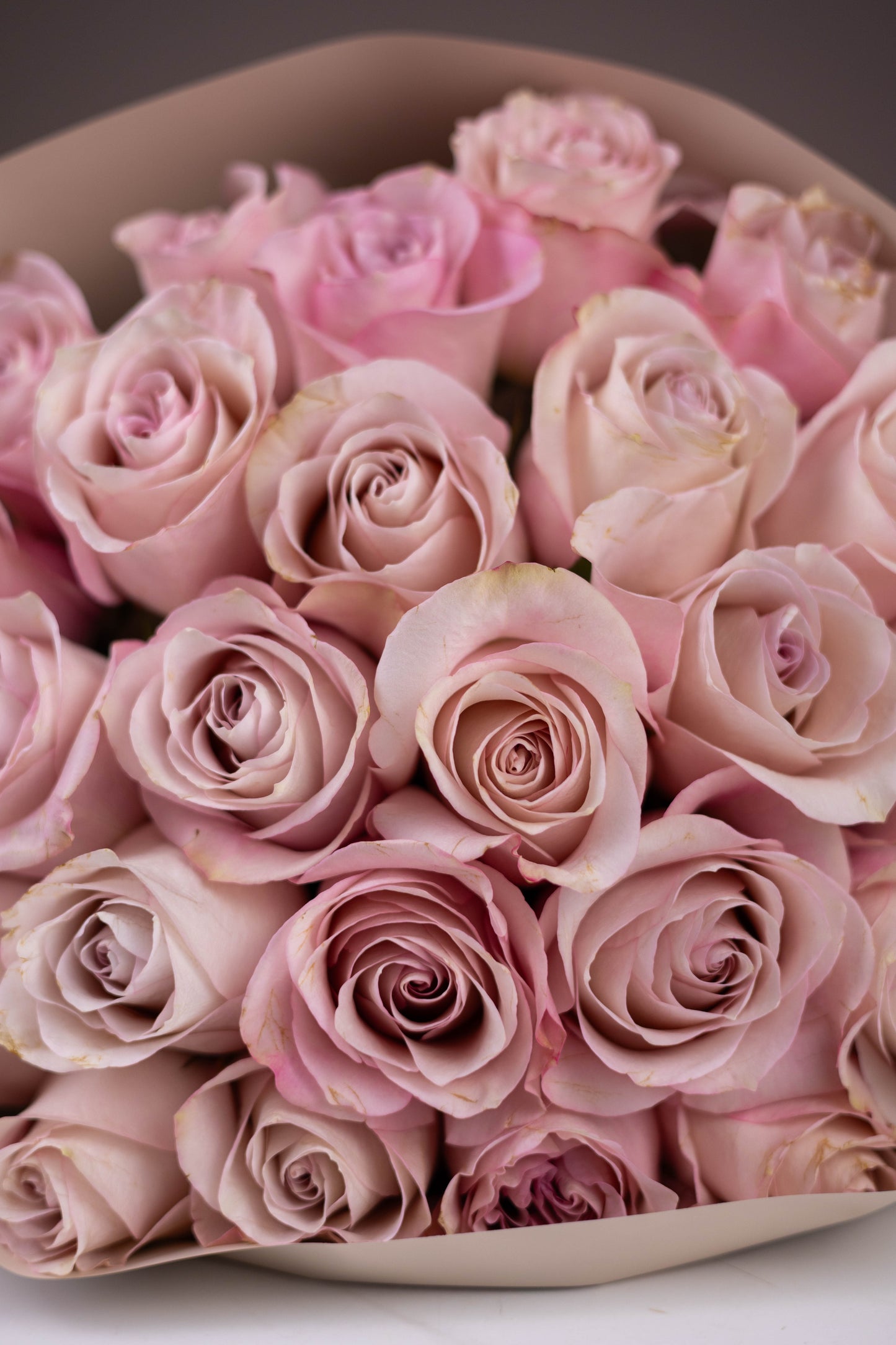 Bouquet of pink roses in a heart-shaped container on a white background