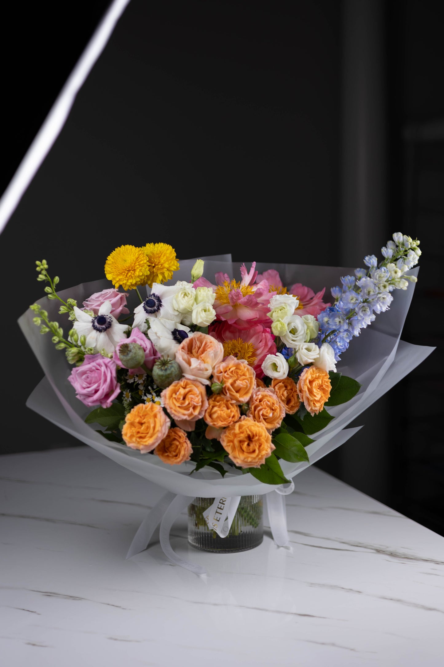 Full bouquet view with vibrant colors in a glass vase on a marble table