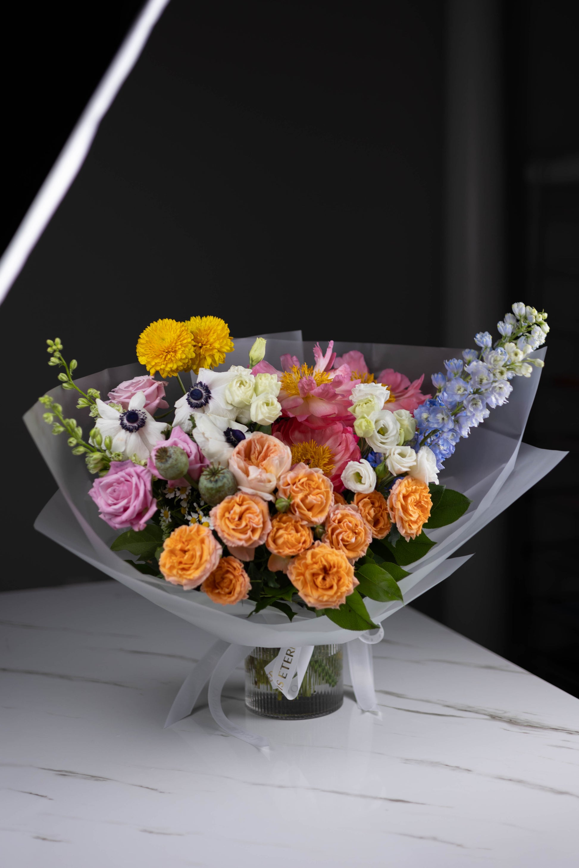 Full bouquet view with vibrant colors in a glass vase on a marble table