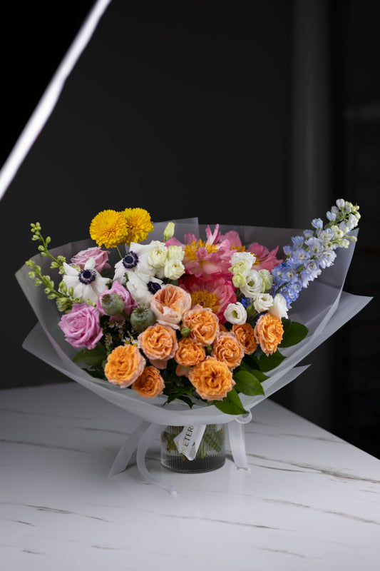 Full bouquet view with vibrant colors in a glass vase on a marble table