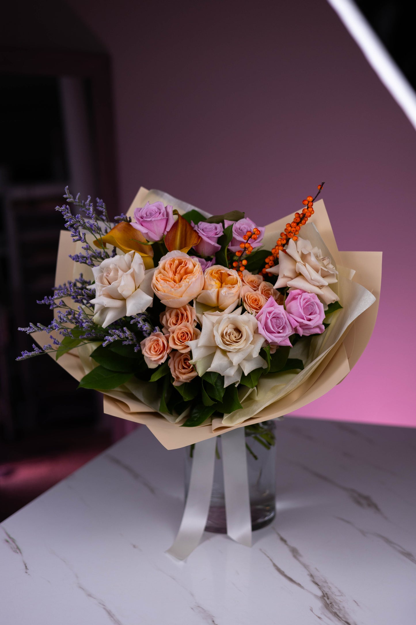 Bouquet of flowers on a marble surface with a pink gradient background