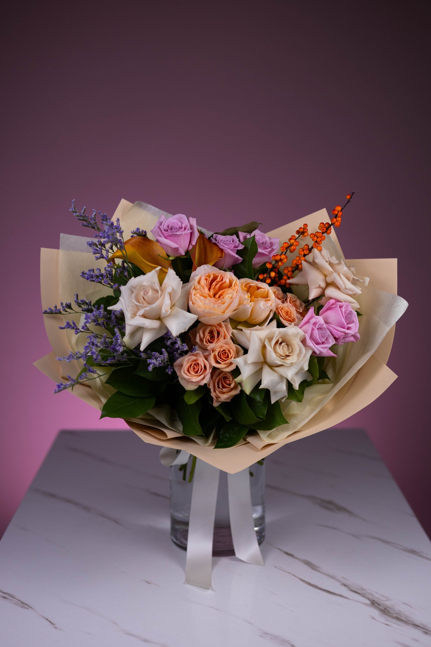 Bouquet of flowers on a marble surface with a purple background