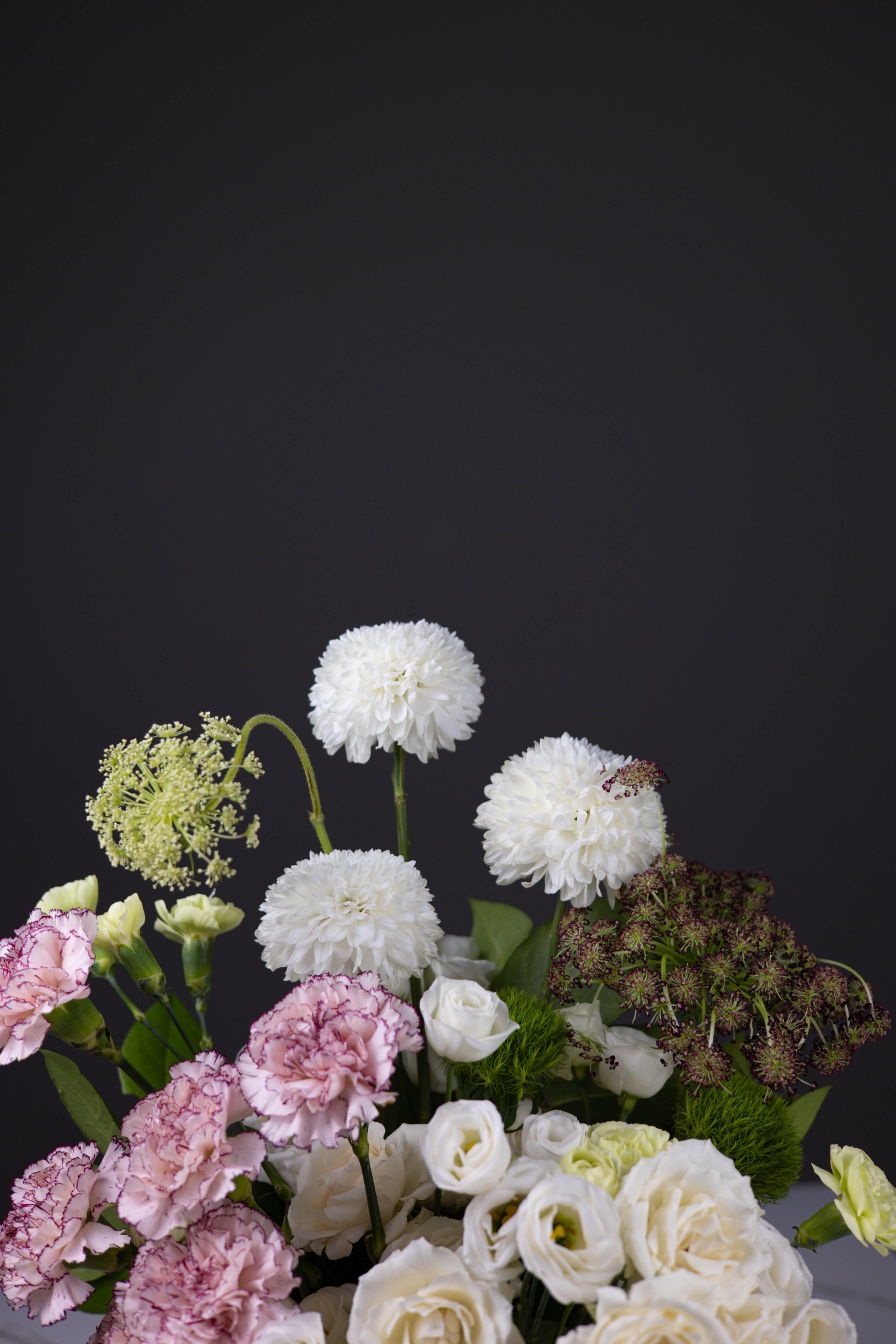 Top portion of floral arrangement showcasing white dahlias, Queen Anne’s lace, and rich textures