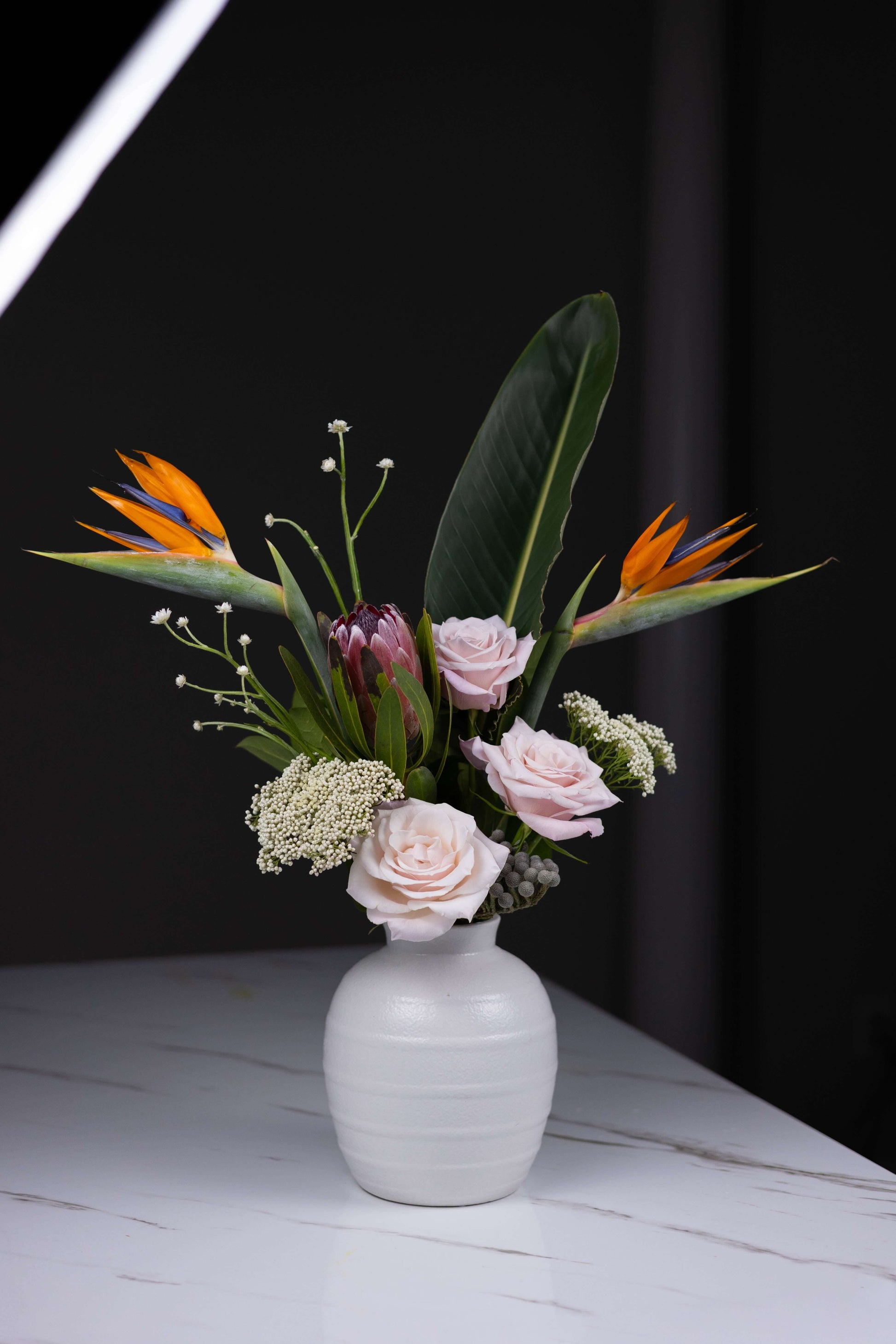 Charlotte luxury floral design featuring blush roses and bold tropical stems