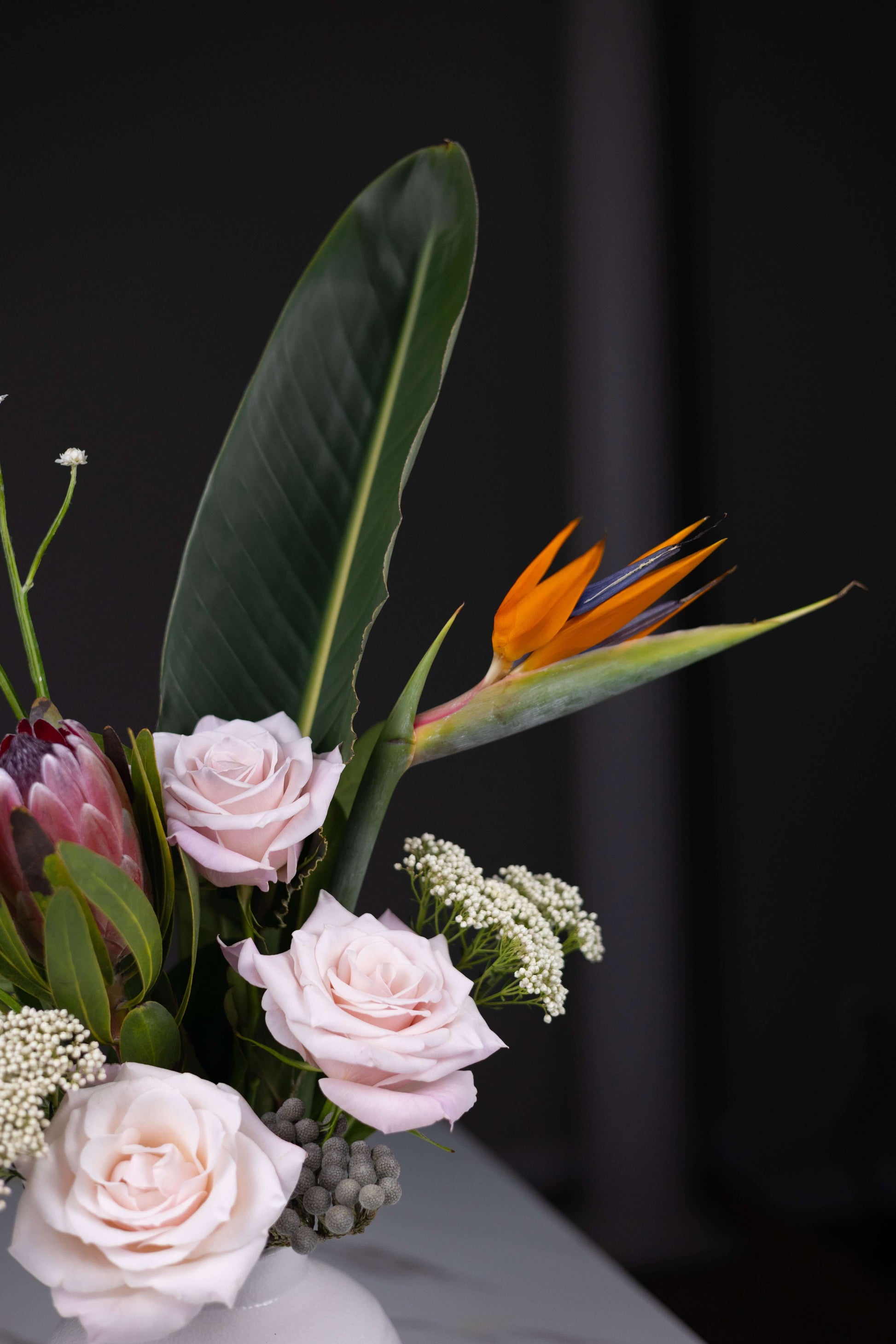 Statement floral arrangement in ceramic vase with Birds of Paradise and roses