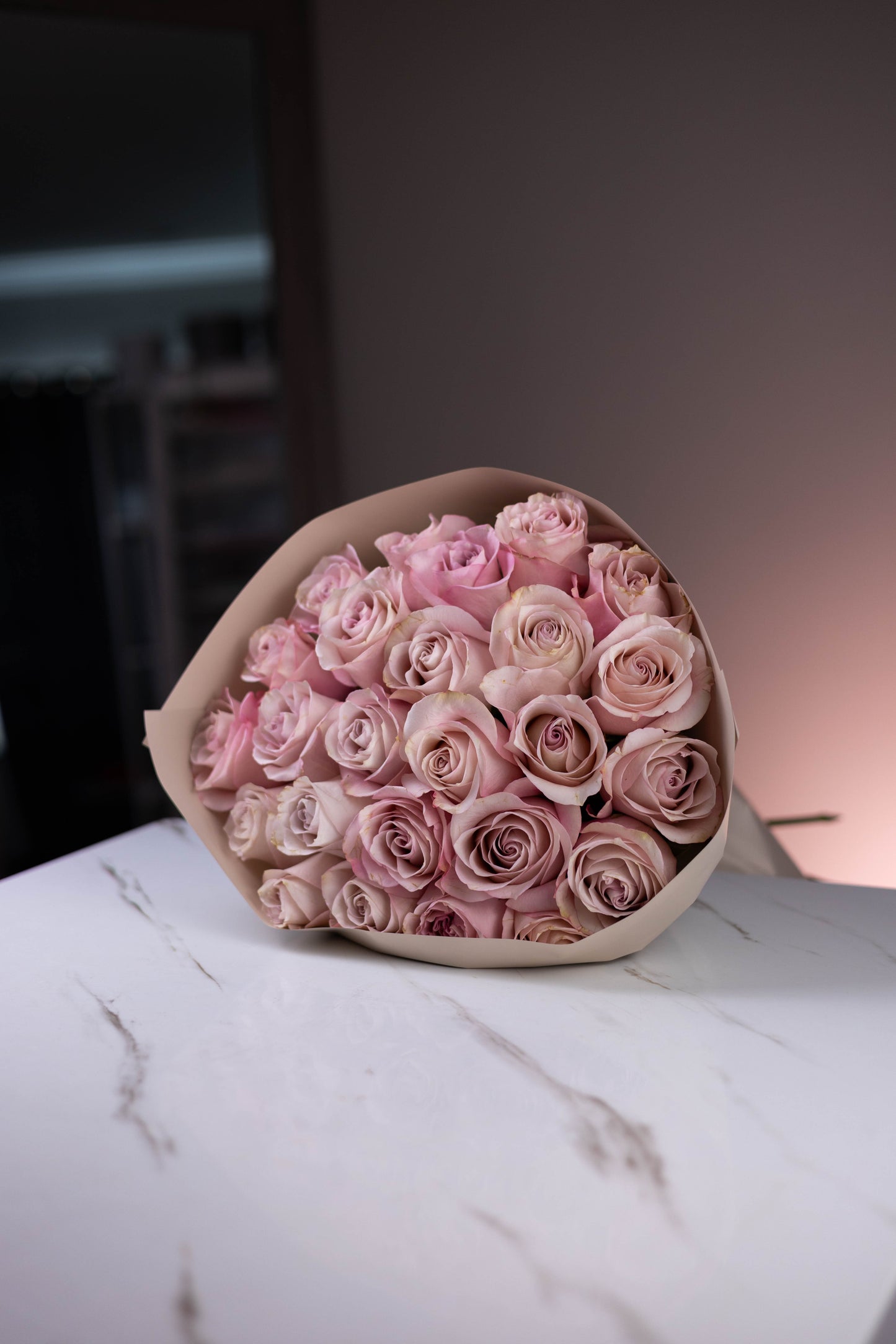 Bouquet of pink roses on a marble surface with a blurred background