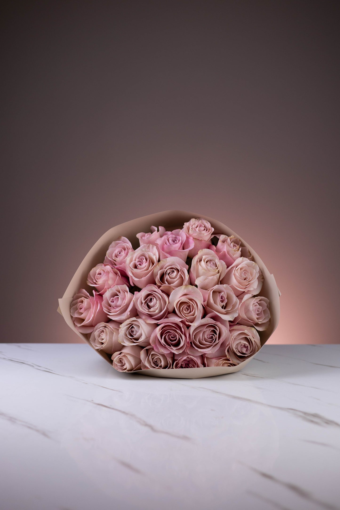 Bouquet of pink roses on a white surface with a gradient background
