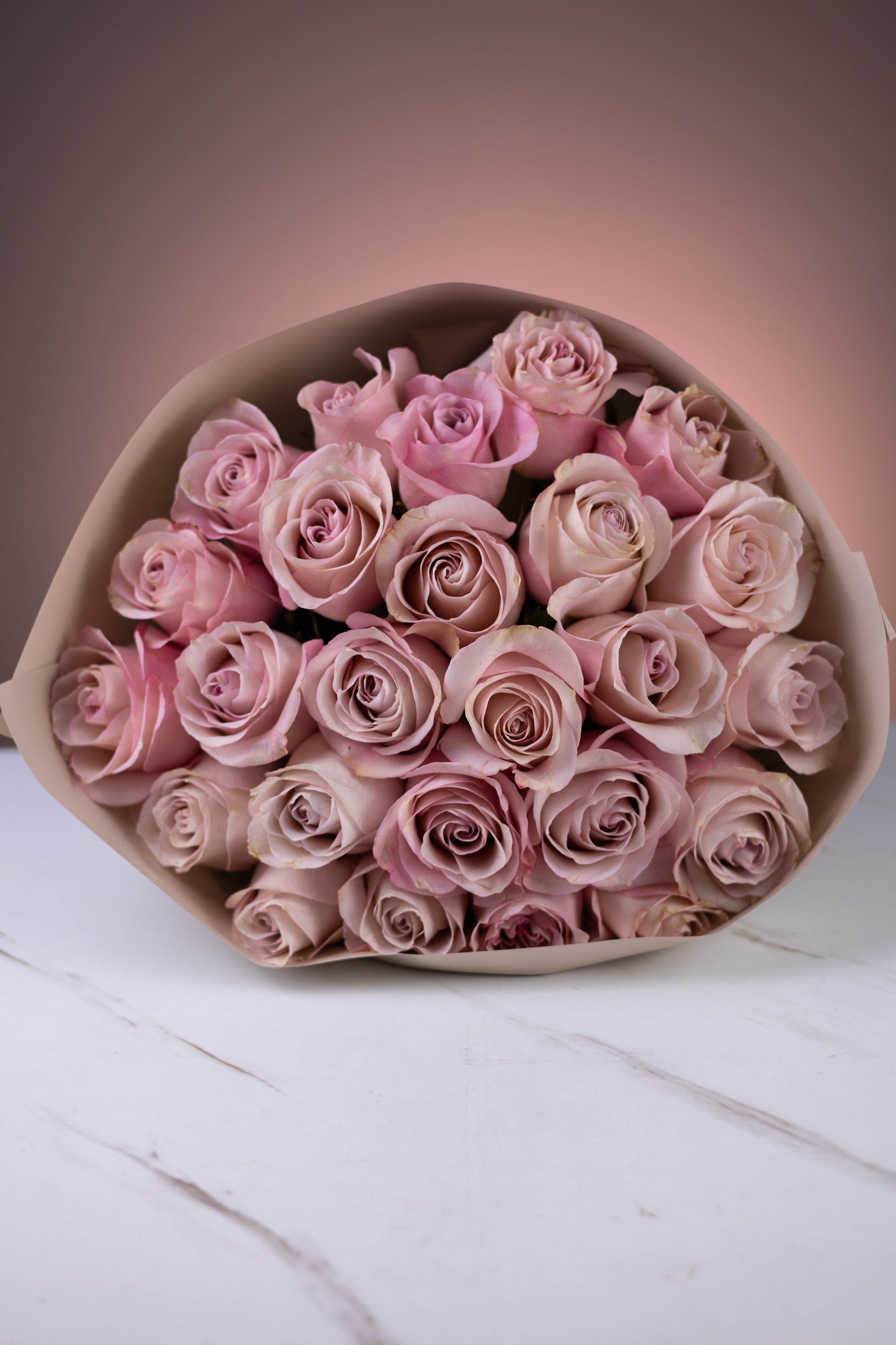 Bouquet of pink roses on a white surface with a soft pink background