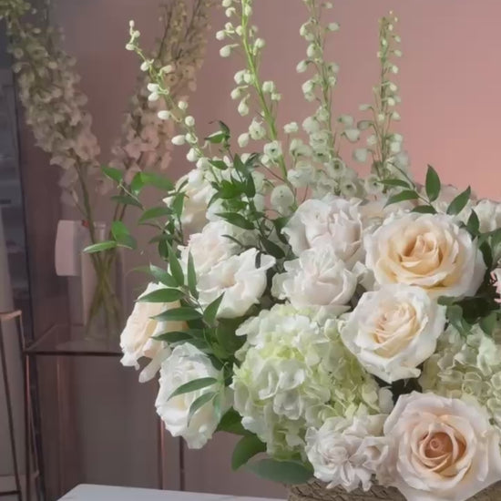 Elegant ivory bouquet styled in a rustic basket with soft evening lighting